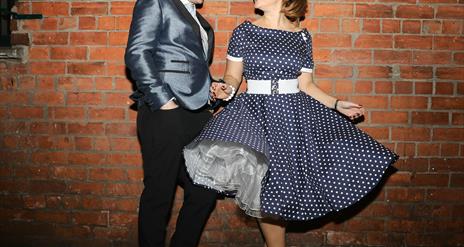 Photo of The Soda Popz in 50's style dress and suit.
