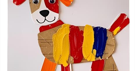 A crafted puppy make of various pieces of cardboard and other materials, painted with a range of colours.