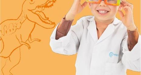 A smiling child in a white professor coat.