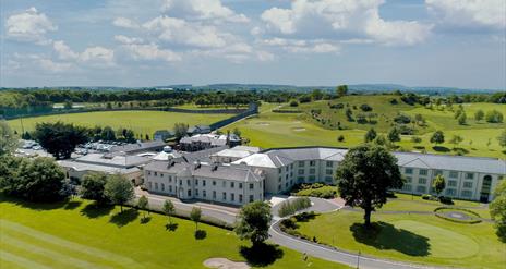 Drone view of the exterior at Roe Park Resort, fluorescent green natural surroundings and golf course.