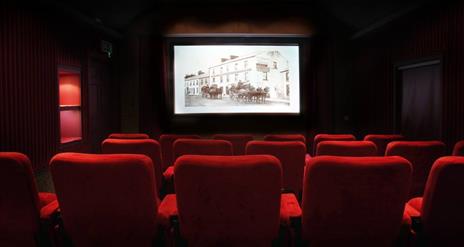 Image shows a movie theatre with red seats