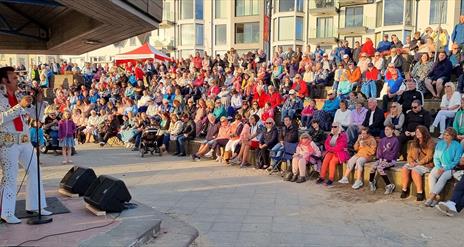 Elvis Show at Red Sails Festival with a full crowd sitting in front of him