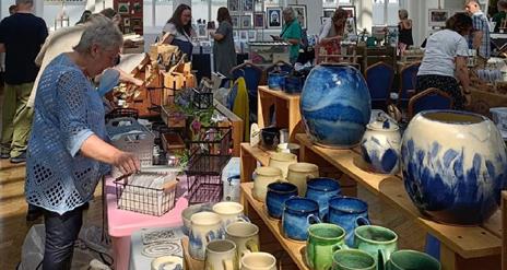 people browsing indoor craft market stalls