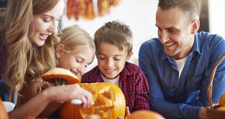 family carving a pumpkin