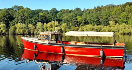 MV Kingfisher boat on the river with Mountsande in  background.