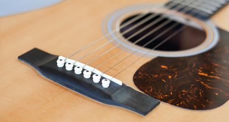 Close up photograph of an acoustic guitar