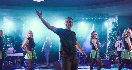 Irish dancers on stage backed by a live band