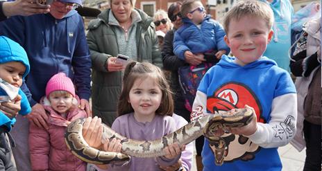 Children holding a snake