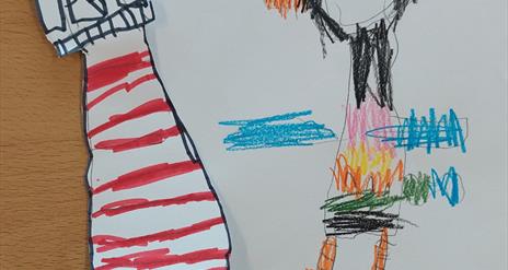 A child's drawing of a colourful puffin accompanied by a cut-out lighthouse.