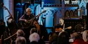 two men playing guitars onstage at Atlantic Sessions