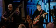 two men playing guitars onstage at Atlantic Sessions
