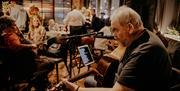 a man plays a guitar to people in a restaurant
