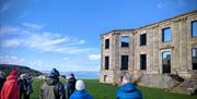 Bob Picken guiding a group dressed in outdoor clothing and hearing stories of the Earl Bishop