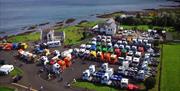 A truck display in car park with the sea and mountains in the background