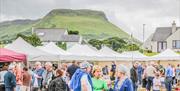 People browsing busy outdoor market stalls