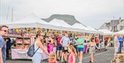 People browsing busy outdoor market stalls