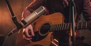 close up of acoustic guitar and microphone