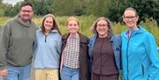 a group of people all holding each other by the shoulders and smiling