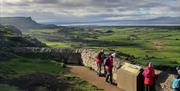 a group of walkers peer over a stone wall