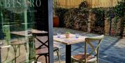 Tables and chairs outside the Bistro on a sunny day.