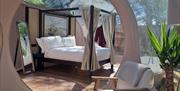 View of bedroom area from living room with chair and table with free standing mirror in view