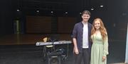 megan paul and andrew robinson in front of an auditorium