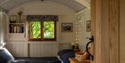 Hut interior showing king size bed and window to trees