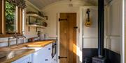 Hut interior showing kitchen and stove.