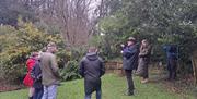 Bob Picken guiding a group dressed in outdoor clothing and hearing stories of the Earl Bishop