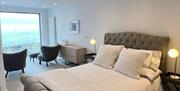 Image of bedroom and chairs looking onto a sea view
