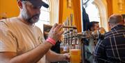 a man pours beer from a draught tap at Portrush Beer Festival
