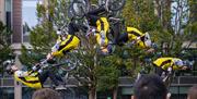 a number of cyclists all in various stages of mid air flips on their bikes