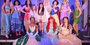 a number of disney princesses on stage with young children