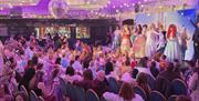 disney princesses on stage in front of a crowd