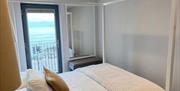 Image of bedroom with 4 poster bed and sea view