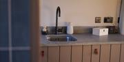 Image of kitchen at The Bothans. Shows the sink and kitchen cabinets.