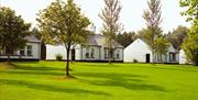 exterior of Brown Trout's Cottage suites which looks on to a golf course