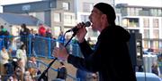 A man wearing a cap singing into a microphone