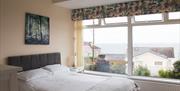 Double bedroom with sea views through large picture window.