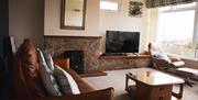 Living room with fireplace, TV and comfortable seating.