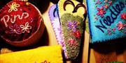 a selection of colour handmade pin cushions and embroidered scissor holders