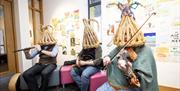 the causeway mummers playing instruments, wearing basket woven hats on their heads