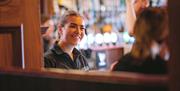 a member of Nellie Rua's bar staff smiles at a customer