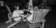 Black and White couple outside on wooden chairs with hot chocolate and fire pit