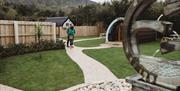 Glamping pod with grass and stone walkway.  Couple in photo
