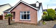 Exterior front and side view of Beachside Bungalow with gravelled drive and garden.