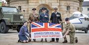 Military service men and women hold an Armed Forces Flag