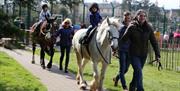 Children wearing hats enjoying short pony rides