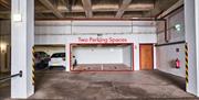 Photograph of underground 2 car parking spaces within gated car park.