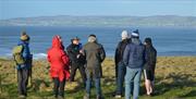 Bob Picken guiding a group in outdoor clothing  w
